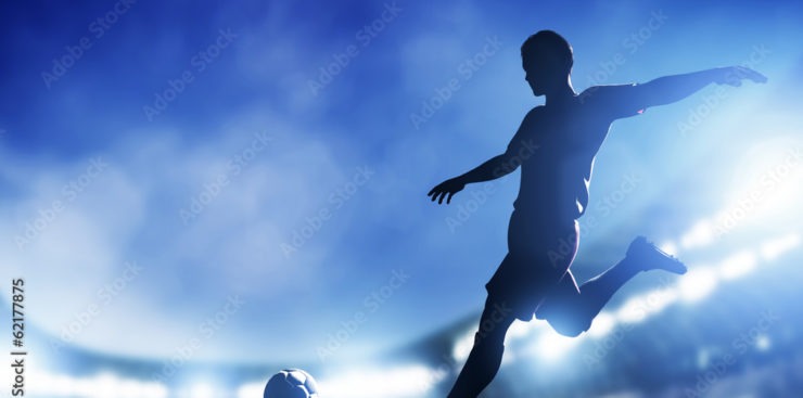 Football, soccer match. A player shooting on goal